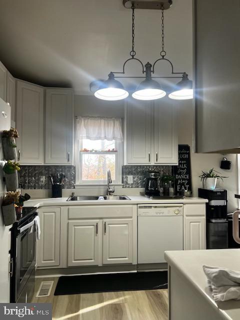 kitchen with white cabinets, white dishwasher, and hanging light fixtures