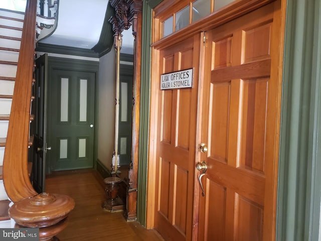 foyer entrance with dark wood-type flooring and ornamental molding