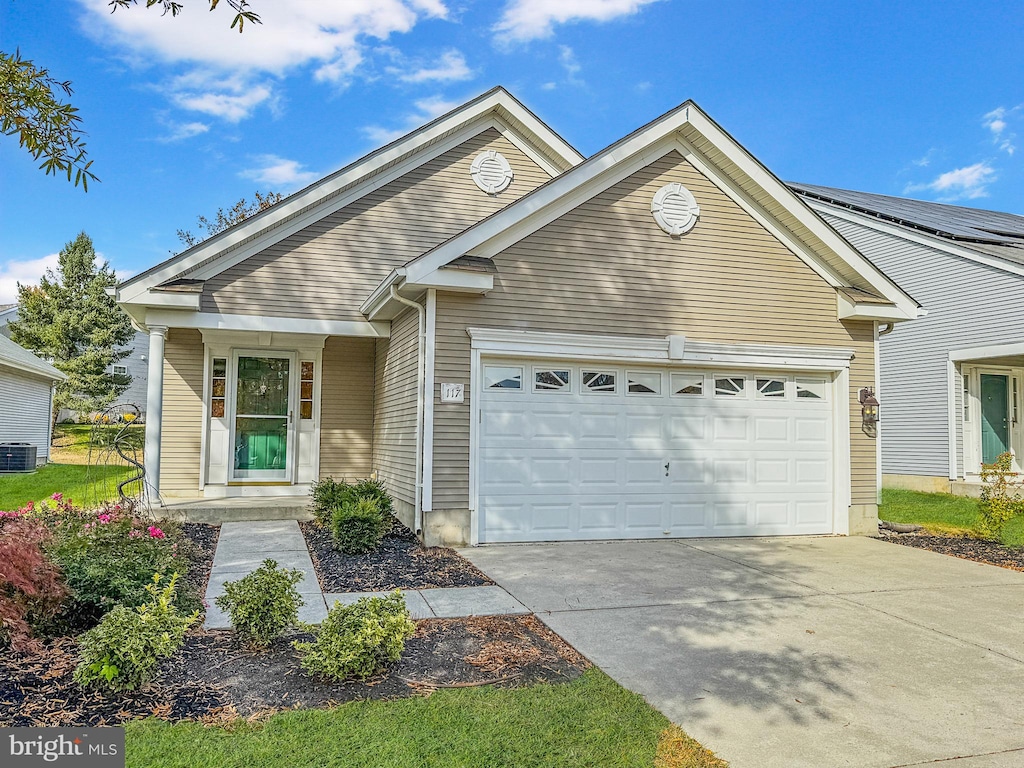 view of front of property featuring a garage and central AC unit