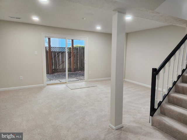 basement featuring light colored carpet and a textured ceiling