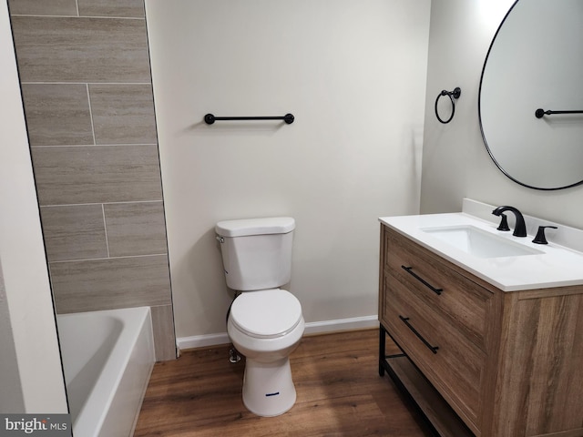 bathroom with hardwood / wood-style flooring, vanity, and toilet