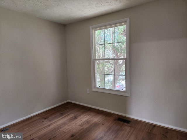 spare room with wood-type flooring and a textured ceiling