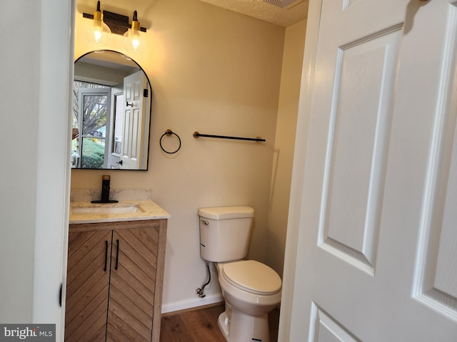 bathroom with vanity, hardwood / wood-style floors, a textured ceiling, and toilet