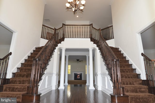 foyer entrance featuring ornamental molding, a high ceiling, and dark hardwood / wood-style flooring