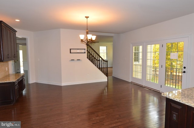 living room with an inviting chandelier and dark wood-type flooring