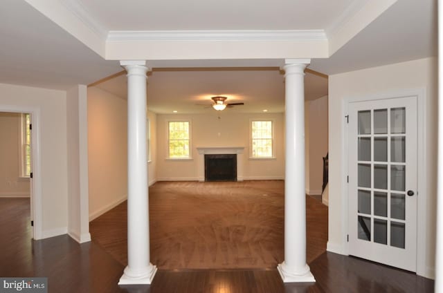 unfurnished living room featuring dark wood-type flooring, ceiling fan, a raised ceiling, and ornamental molding