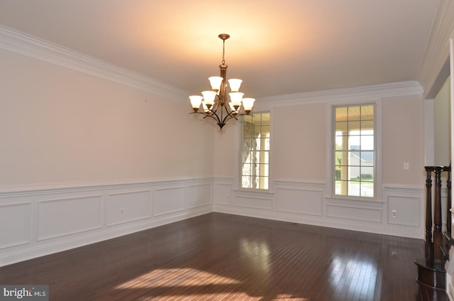 unfurnished dining area featuring dark wood-type flooring, crown molding, and an inviting chandelier