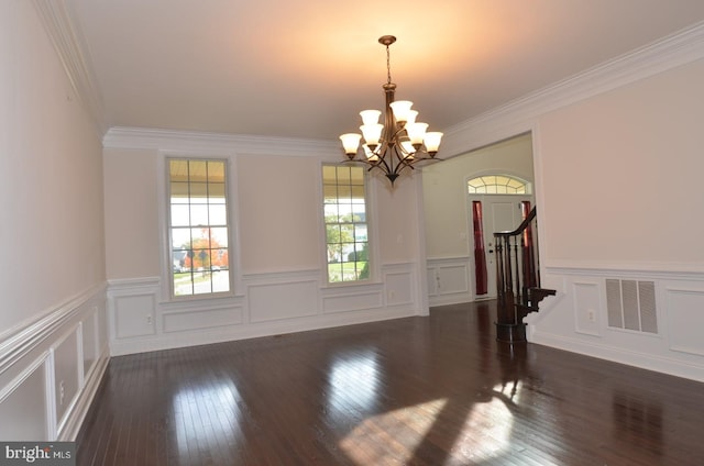 unfurnished room with ornamental molding, an inviting chandelier, and dark hardwood / wood-style floors