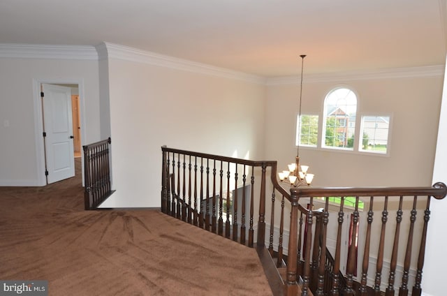 corridor featuring crown molding, an inviting chandelier, and dark colored carpet