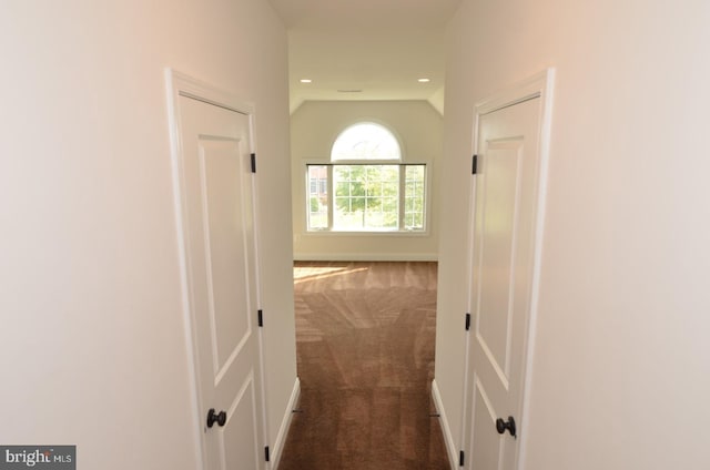 hall featuring dark colored carpet