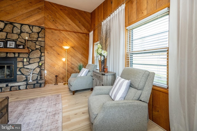 sitting room featuring light hardwood / wood-style flooring, a fireplace, and wood walls