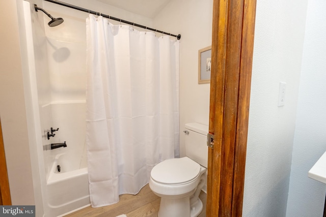 bathroom with hardwood / wood-style floors, shower / tub combo with curtain, and toilet