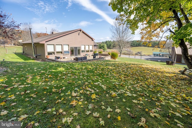 rear view of property with a yard and a patio