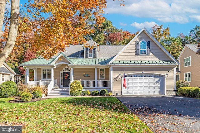 view of front facade with a porch, a front yard, and a garage