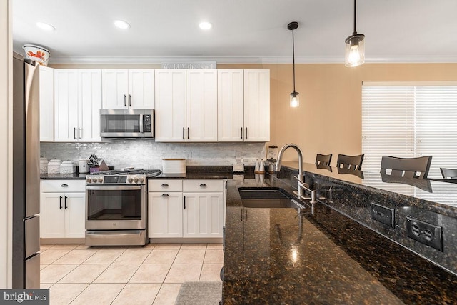 kitchen with sink, hanging light fixtures, white cabinetry, stainless steel appliances, and dark stone countertops