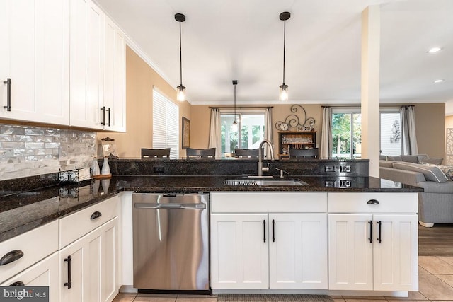 kitchen featuring pendant lighting, dark stone countertops, sink, and stainless steel dishwasher