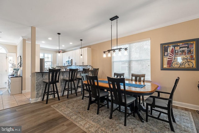 dining room featuring an inviting chandelier, light hardwood / wood-style flooring, and crown molding