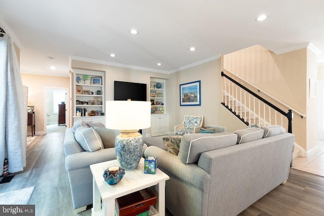 living room featuring ornamental molding, built in shelves, and hardwood / wood-style flooring