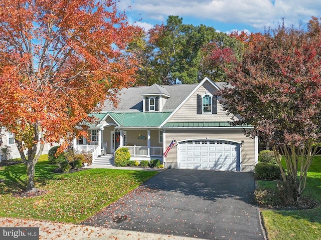 view of front of house featuring a front yard, a garage, and a porch