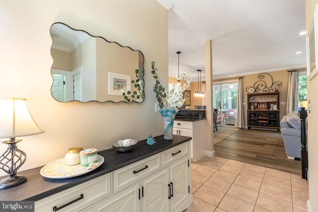 kitchen with light hardwood / wood-style floors, hanging light fixtures, plenty of natural light, and white cabinets