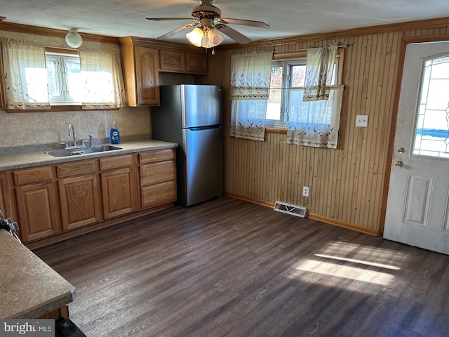 kitchen with dark hardwood / wood-style flooring, stainless steel fridge, decorative backsplash, and wood walls