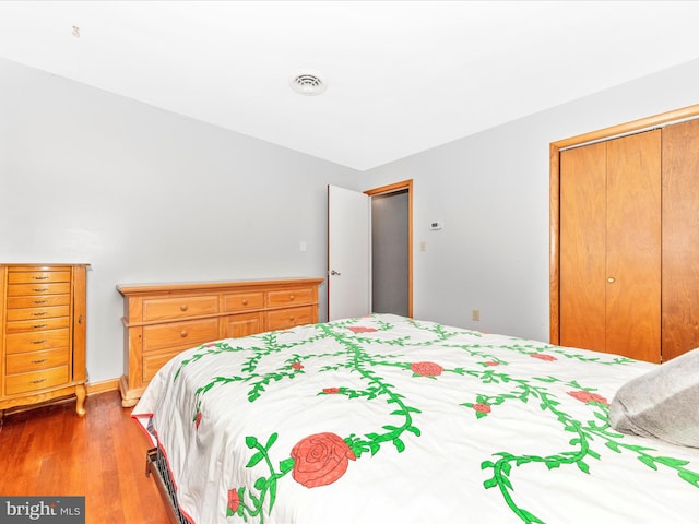 bedroom with a closet and hardwood / wood-style floors