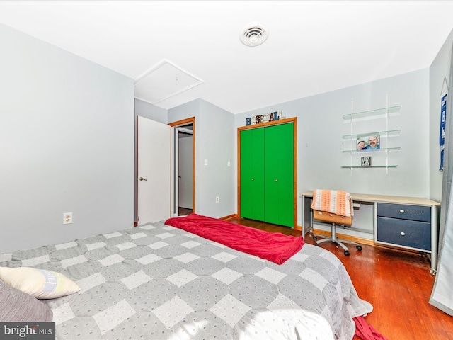 bedroom with dark wood-type flooring and a closet