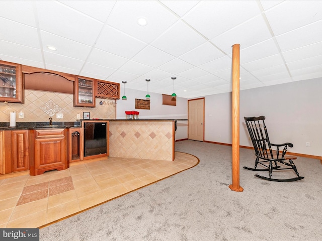 kitchen with wine cooler, a drop ceiling, pendant lighting, and light colored carpet