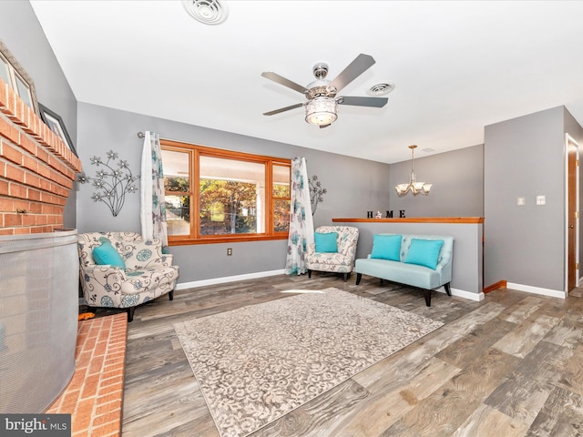 sitting room featuring hardwood / wood-style floors and ceiling fan with notable chandelier