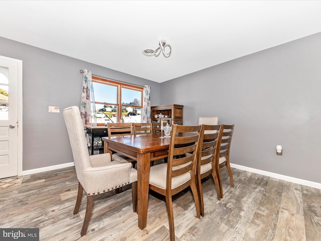 dining space with wood-type flooring