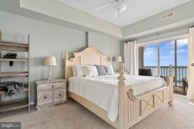 carpeted bedroom with a water view and ceiling fan