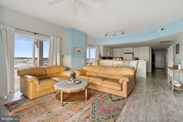 living room with light wood-type flooring and ceiling fan