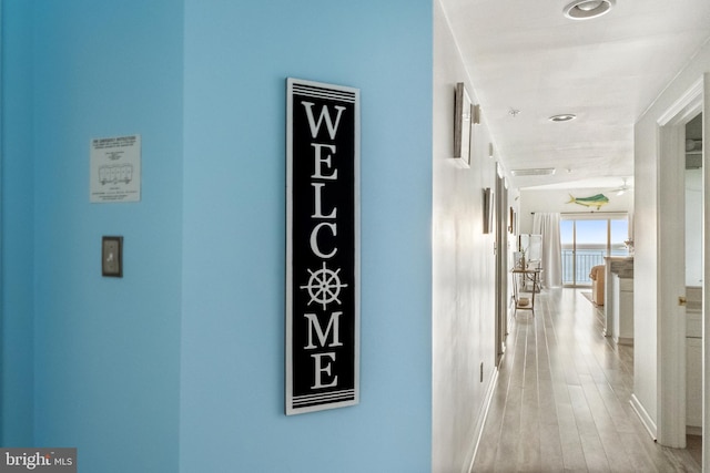 corridor with light hardwood / wood-style flooring