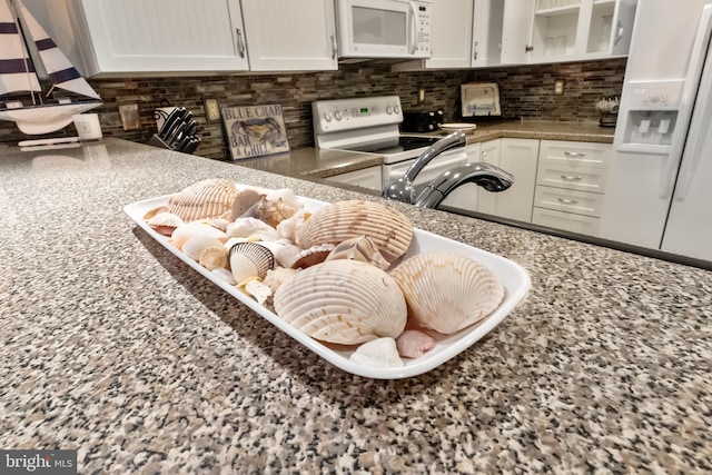 kitchen featuring white appliances, backsplash, and white cabinets