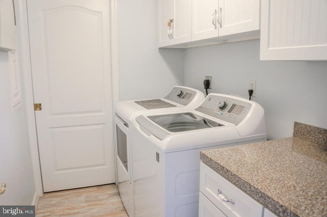 washroom featuring cabinets, separate washer and dryer, and light wood-type flooring