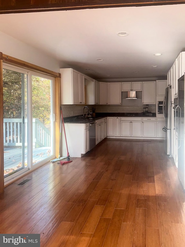 kitchen featuring decorative backsplash, dark hardwood / wood-style floors, sink, white cabinetry, and appliances with stainless steel finishes