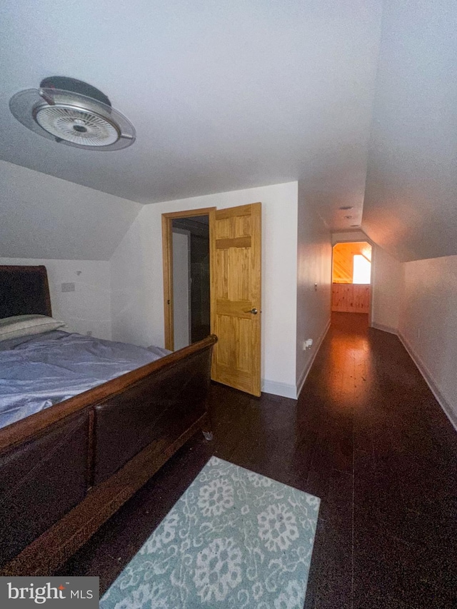 bedroom with dark wood-type flooring and vaulted ceiling