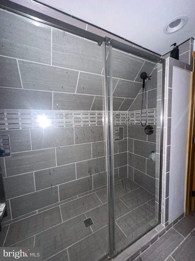 bathroom featuring a shower with door