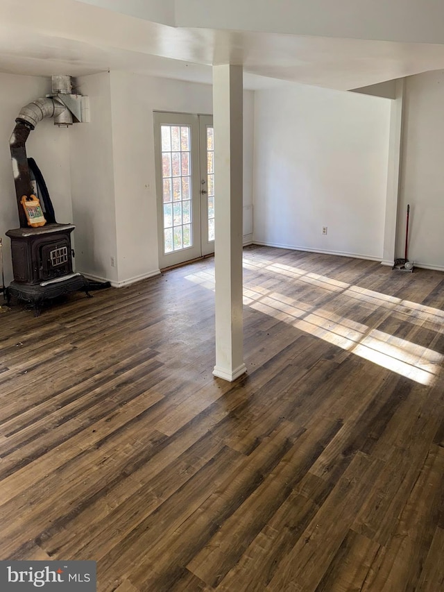 unfurnished living room featuring a wood stove and dark hardwood / wood-style floors