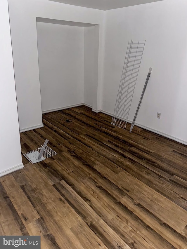 unfurnished room with dark wood-type flooring