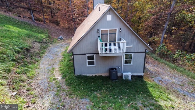 view of home's exterior featuring a yard, a balcony, central AC unit, and ac unit