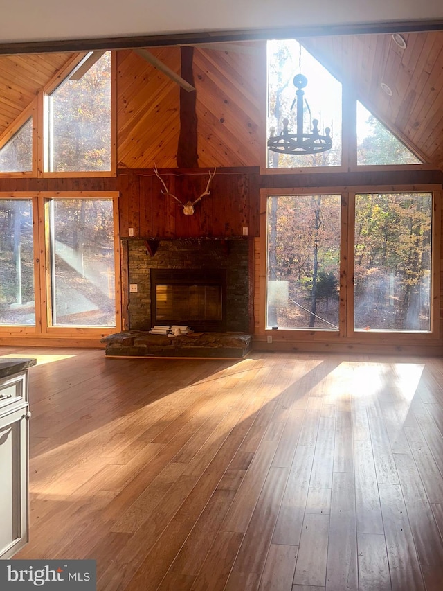 unfurnished living room featuring wood walls, hardwood / wood-style flooring, and a wealth of natural light