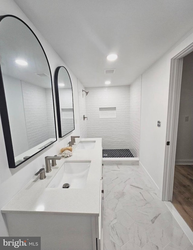 bathroom featuring vanity, hardwood / wood-style flooring, and tiled shower