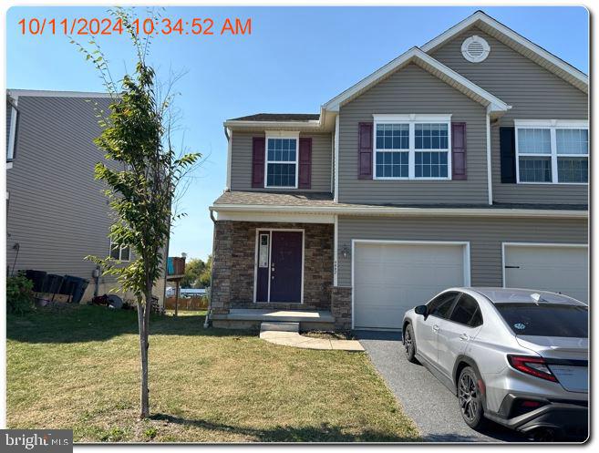 view of front of property featuring a garage and a front lawn