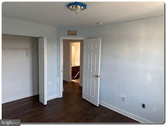 unfurnished bedroom featuring dark hardwood / wood-style flooring and a closet