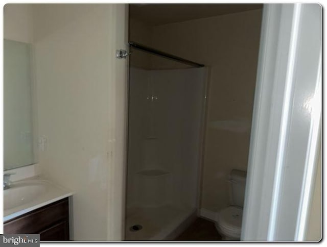 bathroom with vanity, toilet, and walk in shower