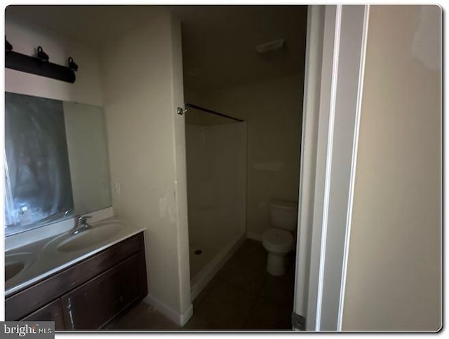 bathroom featuring toilet, vanity, and walk in shower