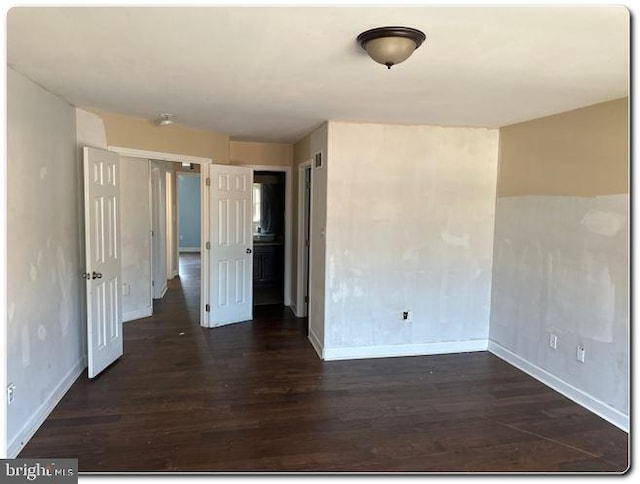 empty room with dark hardwood / wood-style flooring