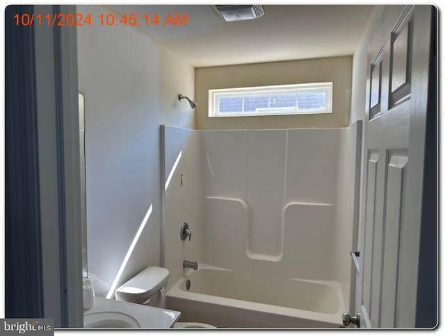 bathroom featuring washtub / shower combination and toilet