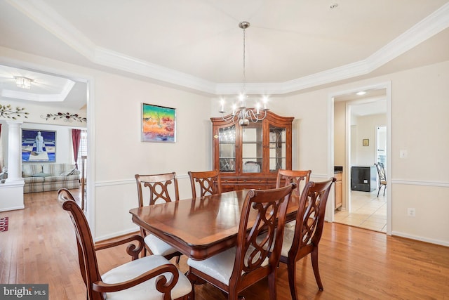 15303 Glastonbury Way, Upper Marlboro, MD 20774 - dining area with a raised ceiling, light wood finished floors, a chandelier, crown molding, and ornate columns